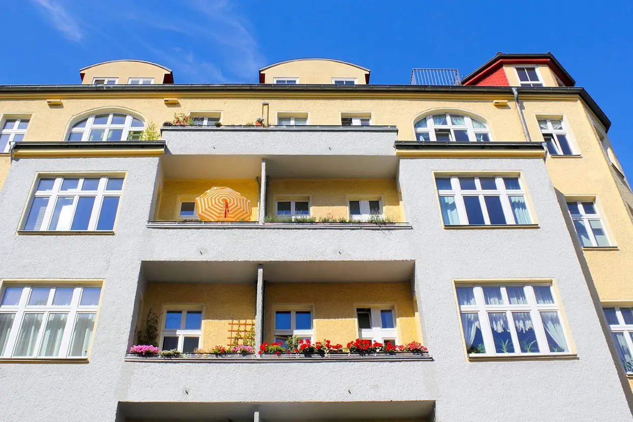 Gelbe Altbaufassade mit Balkonen
